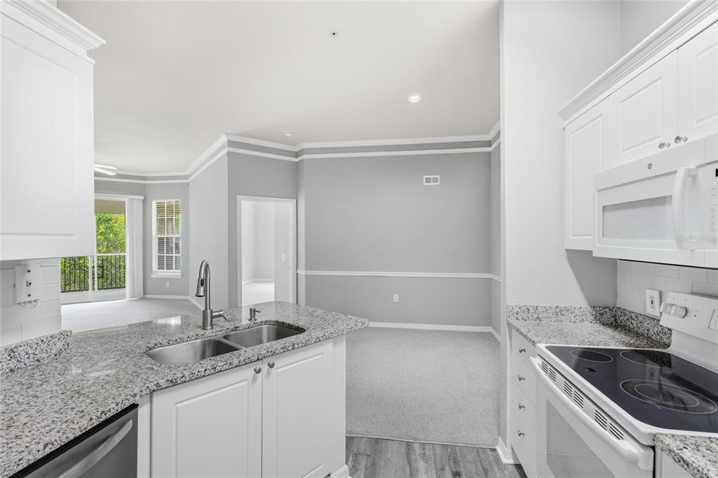 5122 Northridge Road, Unit 307 Sarasota, FL 34238 - Photo 11 of 51 a kitchen with a sink stove and cabinets