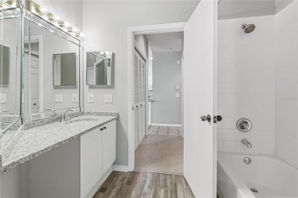 5122 Northridge Road, Unit 307 Sarasota, FL 34238 - Photo 24 of 51 a bathroom with a granite countertop sink a mirror a bathtub and shower