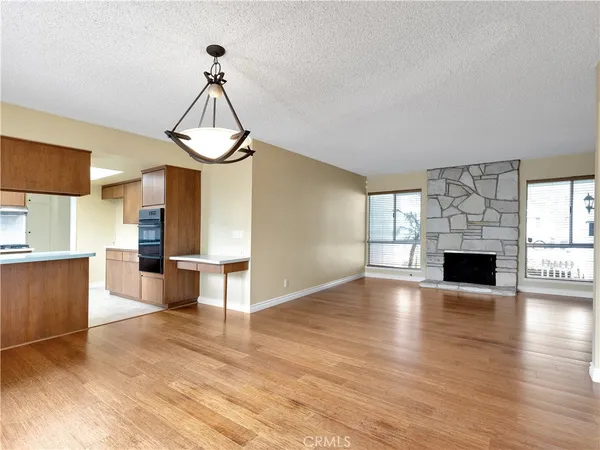 a view of empty room with wooden floor and fireplace