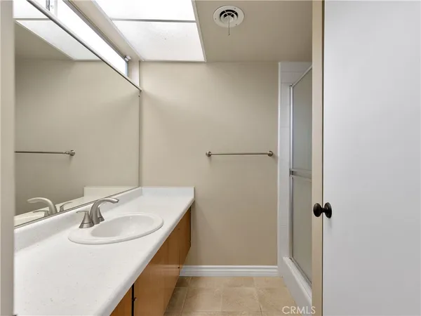 a bathroom with a granite countertop sink a toilet a mirror and shower