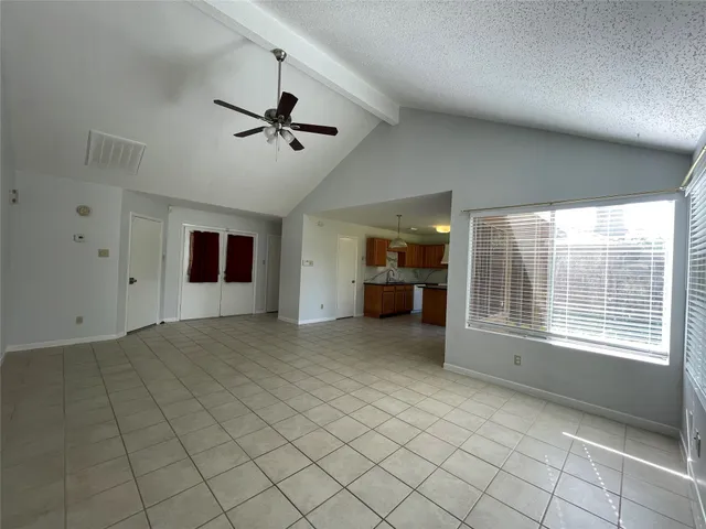 en empty room with windows and ceiling fan
