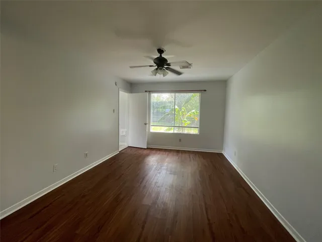 an empty room with a window and wooden floor