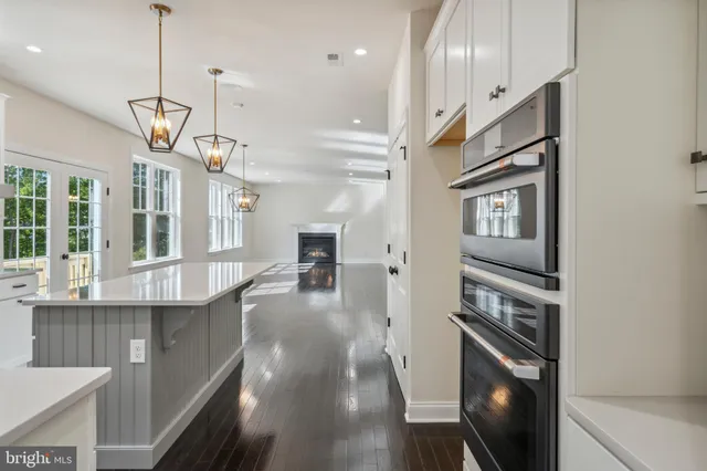 a view of a kitchen with a sink and dishwasher a refrigerator with wooden floor