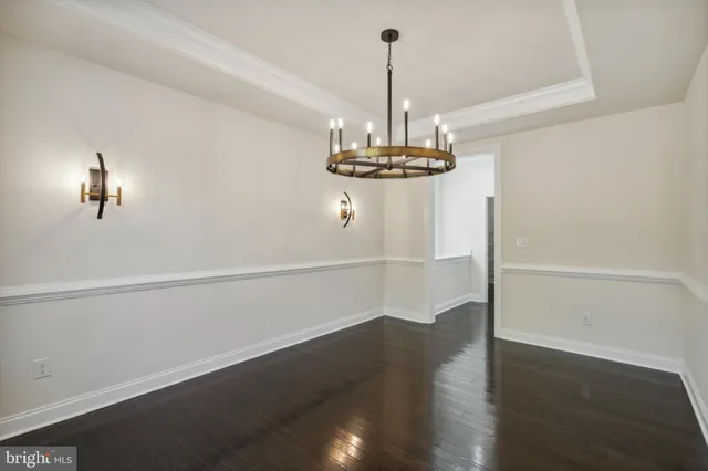 a view of a room with wooden floor chandelier and closet