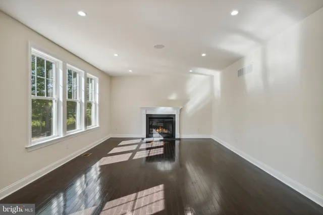 a view of a livingroom with wooden floor and a fireplace