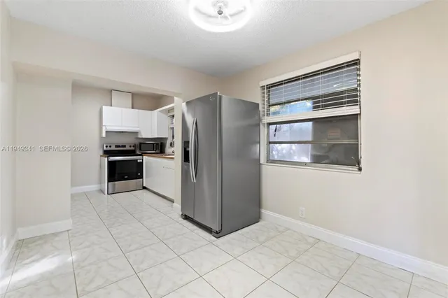 a kitchen with stainless steel appliances granite countertop a refrigerator and a stove top oven