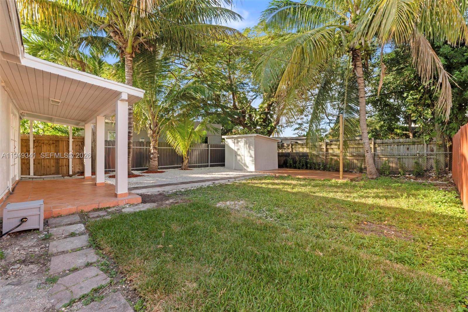 3507 Southwest 25th Terrace Miami, FL 33133 - Photo 20 of 32 a backyard of a house with table and chairs