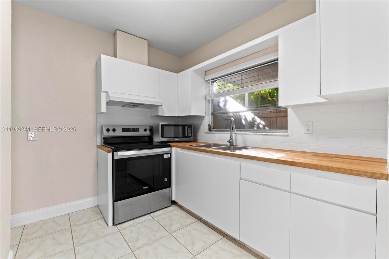 3507 Southwest 25th Terrace Miami, FL 33133 - Photo 10 of 32 a kitchen with stainless steel appliances a sink stove and cabinets