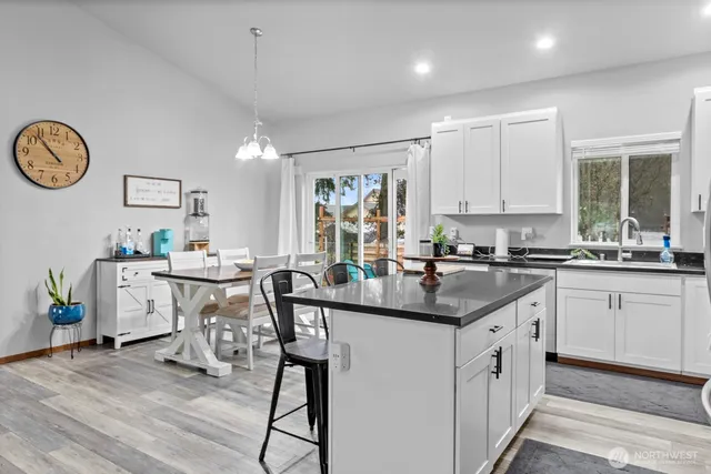 a kitchen with stainless steel appliances granite countertop a stove a refrigerator a sink a stove with white cabinets