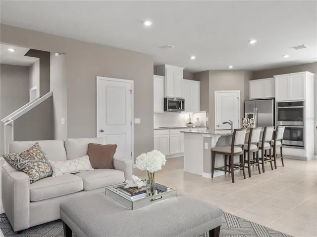 a living room with furniture and kitchen view