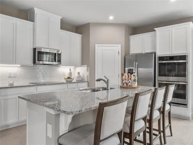 a kitchen with kitchen island a counter top space appliances and cabinets