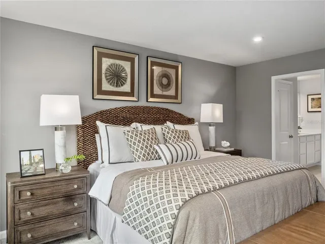 a bedroom with a bed and a lamp on dresser