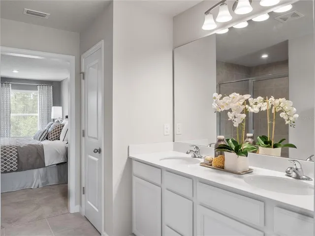 a bathroom with a sink double vanity granite and a mirror