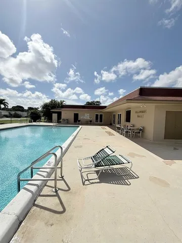 a view of swimming pool with a lounge chairs in front of balcony