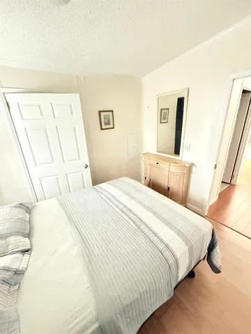 a bedroom with a bed and a large mirror