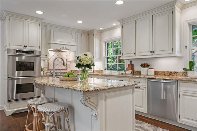 a kitchen with kitchen island granite countertop a stove sink and microwave