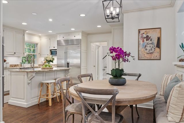 a dining room filled chandelier and kitchen view