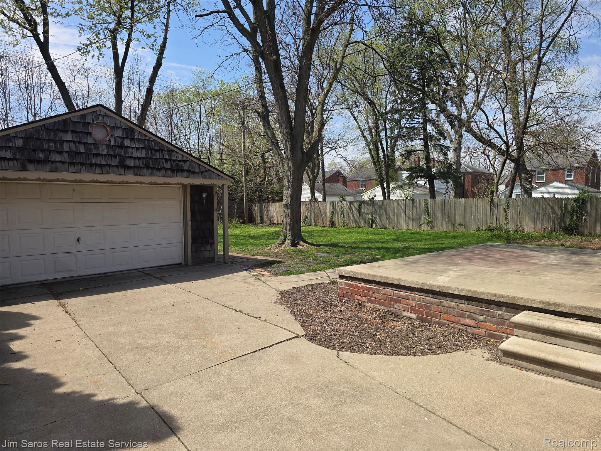 1705 Bournemouth Road Grosse Pointe, MI 48236 - Photo 15 of 20 Fenced yard with an outdoor structure, a detached garage, and a patio