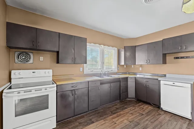 a kitchen with a stove sink and cabinets