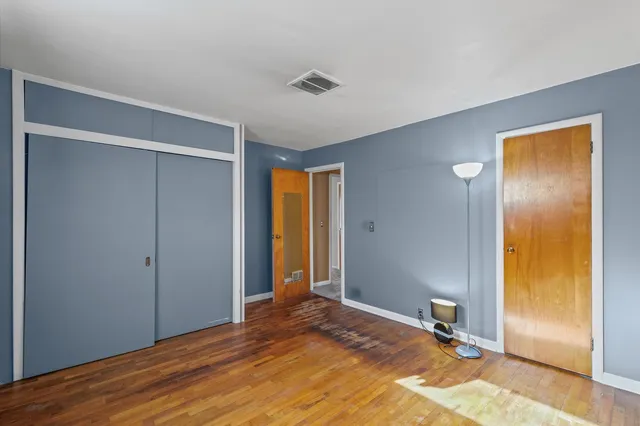 a view of a livingroom with wooden floor and a bathroom