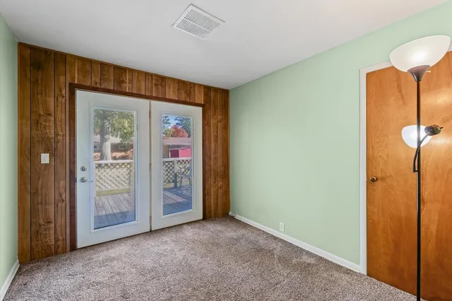 a view of an empty room with closet and a window