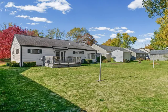 a view of a house with backyard and a tree