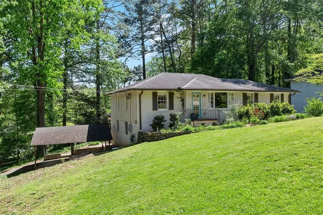 a view of a house with a yard and sitting area