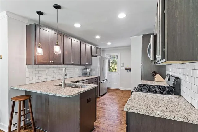 a kitchen with kitchen island granite countertop a sink and stainless steel appliances