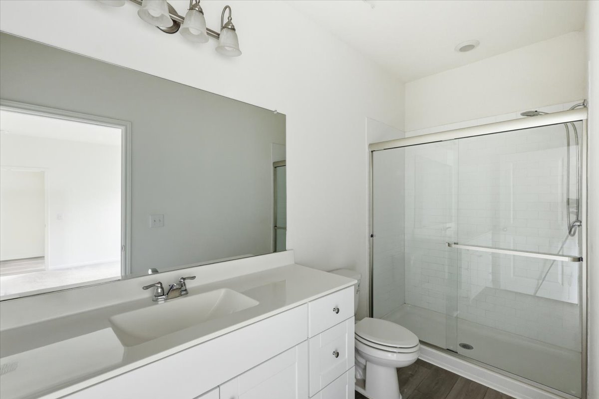 202 Peridot Pass Maxwell, TX 78656 - Photo 14 of 21 A well-lit primary bathroom features a generous vanity, sleek fixtures, and a glass-enclosed shower.