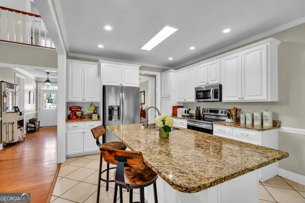a kitchen with stainless steel appliances granite countertop a sink dishwasher a stove refrigerator and cabinets