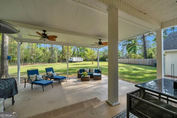 a living room with patio furniture and garden view