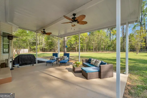 a view of a patio with a table chairs and a floor to ceiling window