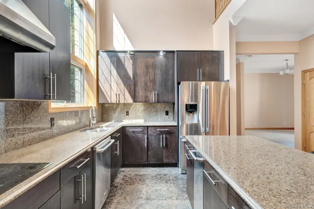 a kitchen with kitchen island granite countertop a sink stove and refrigerator