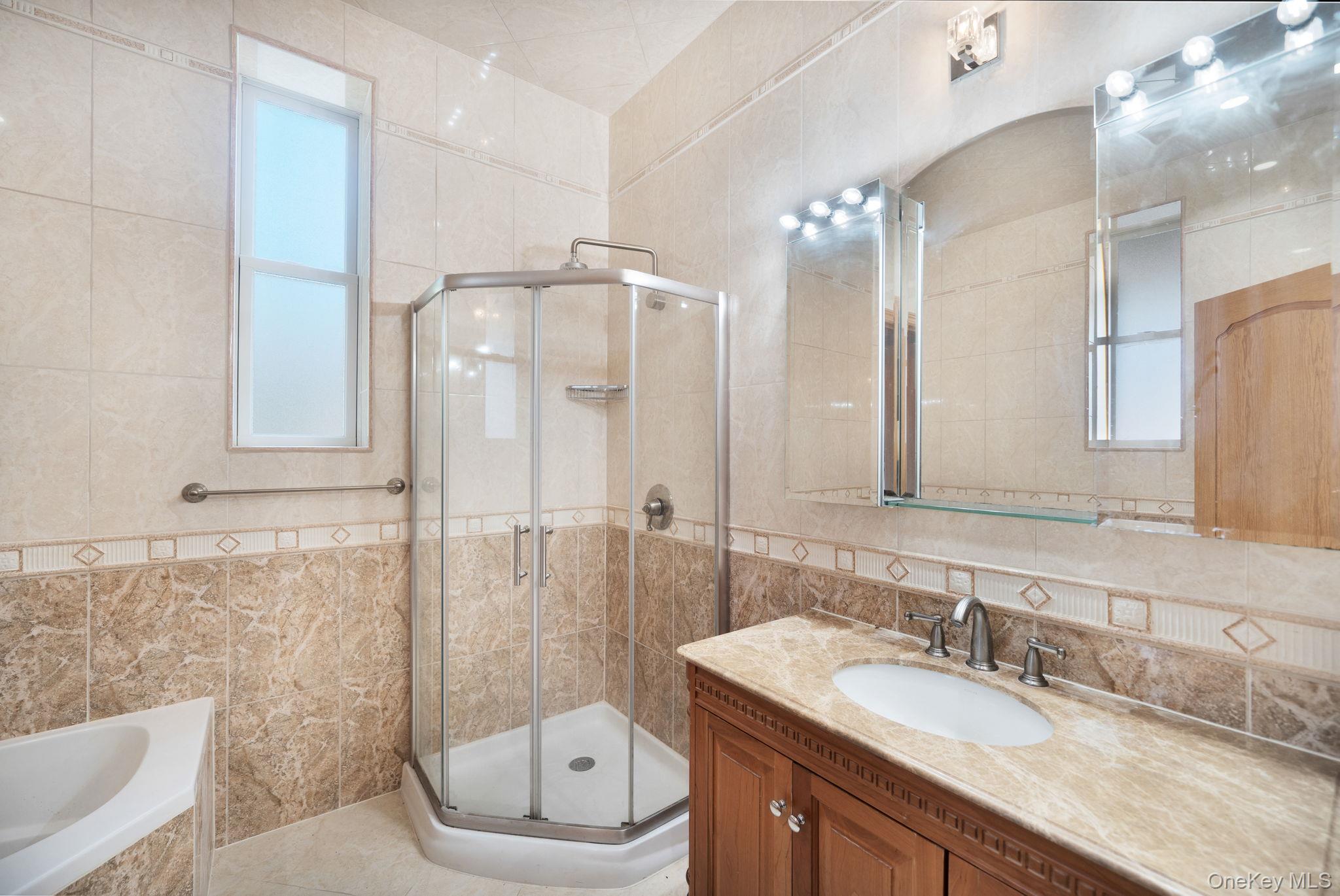 84-29 Kendrick Place Queens, NY 11432 - Photo 19 of 50 a bathroom with a granite countertop sink mirror a toilet and a shower