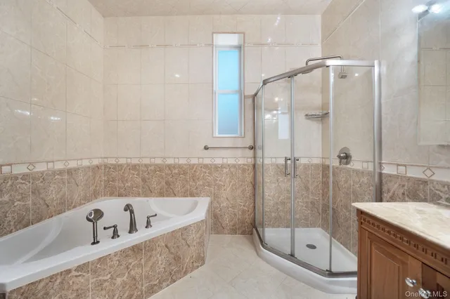 a bathroom with a tub a sink shower and mirror