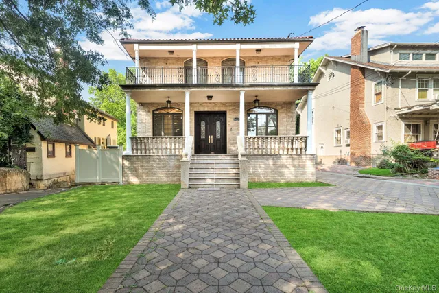 a front view of a house with a yard and garden