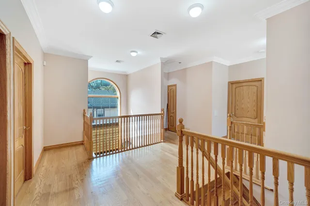 a view of a hallway with wooden floor and windows