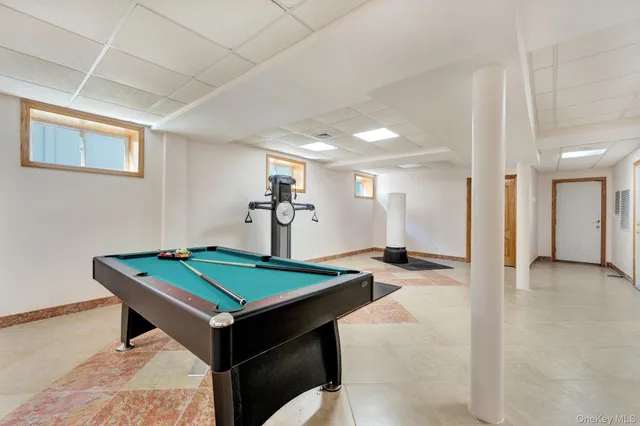 a room with pool table and paintings on the wall