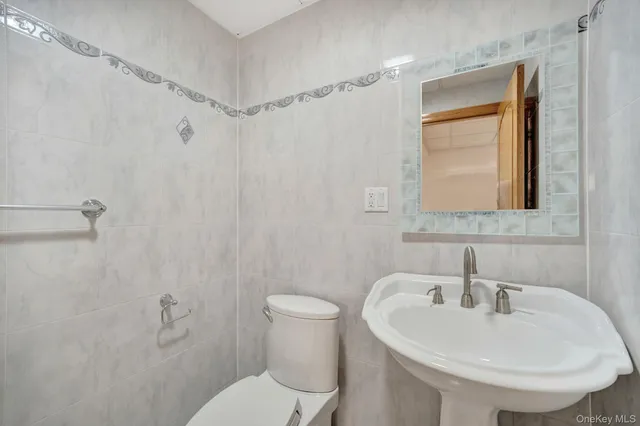 a bathroom with a sink a toilet and a mirror