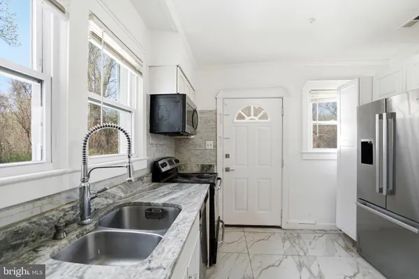 a kitchen with a refrigerator sink and microwave