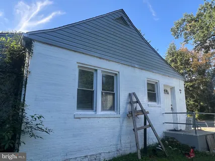 a view of house with backyard and seating area