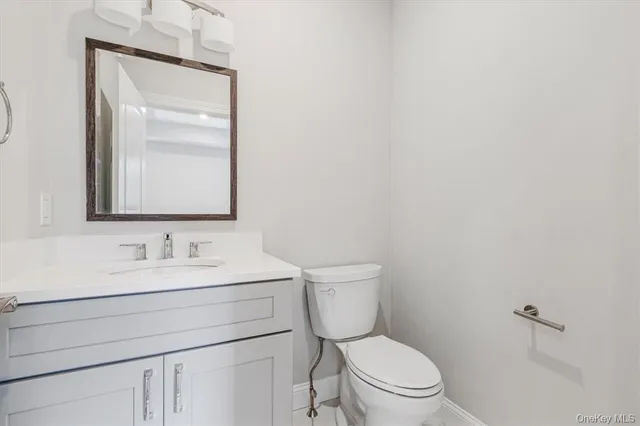 a bathroom with a toilet sink vanity and mirror