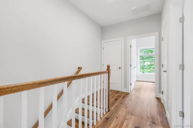 a view of a hallway with wooden floor and staircase