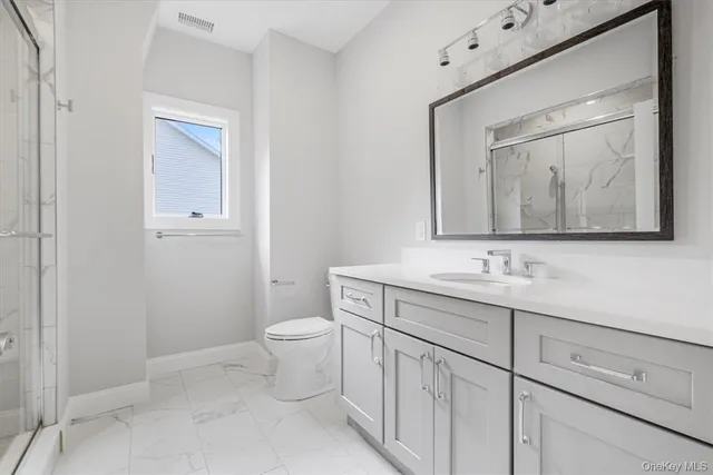 a bathroom with a toilet a sink a vanity and mirror