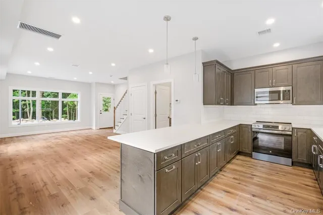 a large kitchen with stainless steel appliances granite countertop a sink and a stove