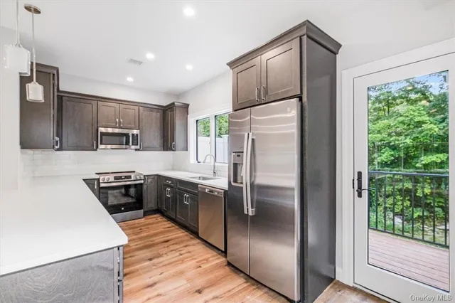 a kitchen with stainless steel appliances granite countertop a refrigerator a stove a sink and dishwasher