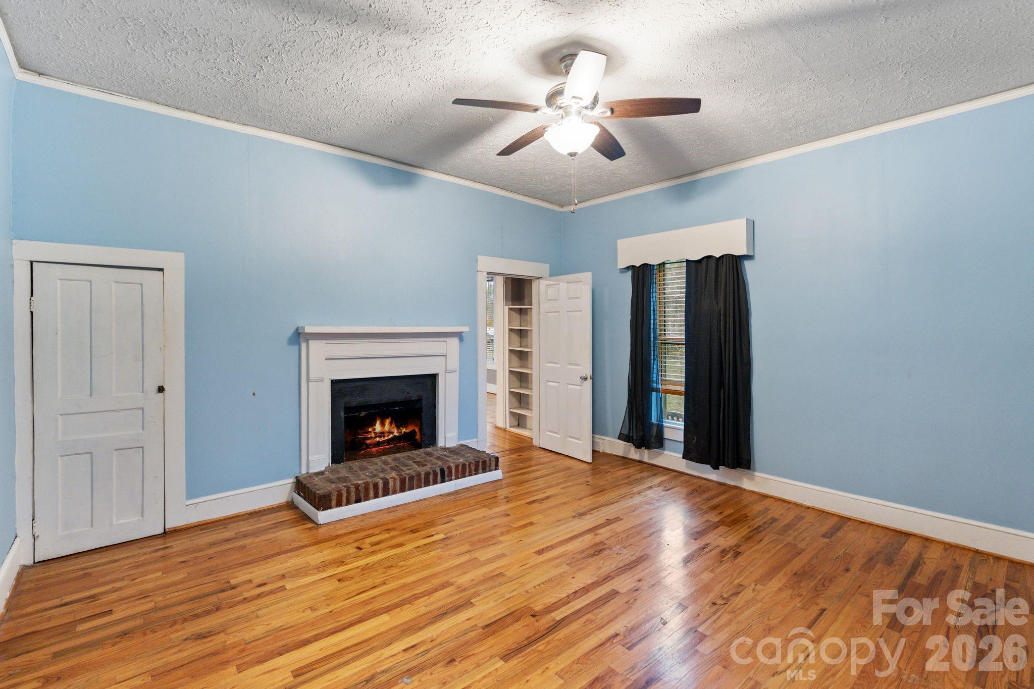 6921 Harmony Grove Road Nebo, NC 28761 - Photo 14 of 21 a view of an empty room with wooden floor fireplace and a window