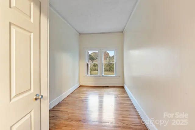 a view of a room with wooden floor and window