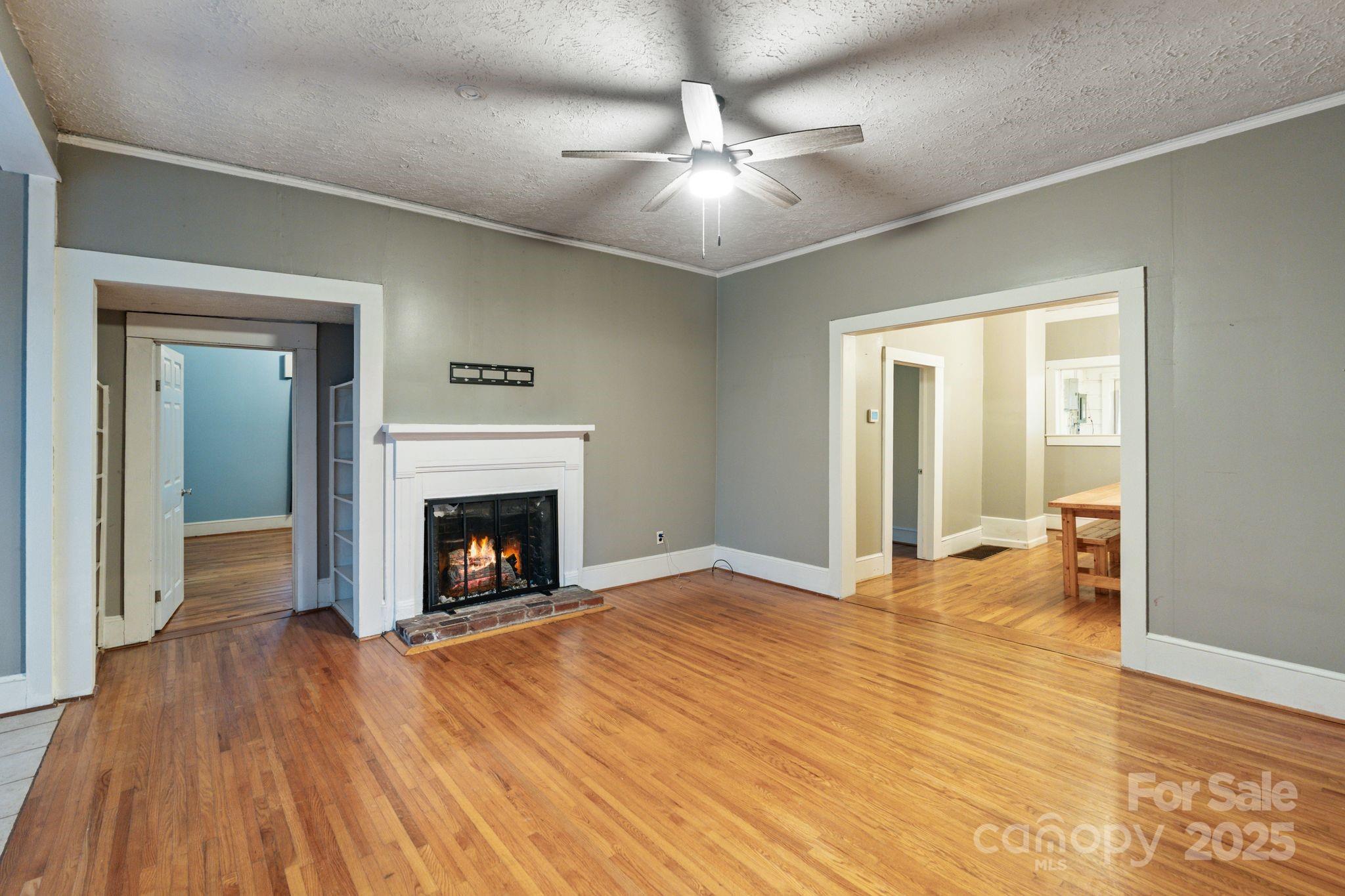 6921 Harmony Grove Road Nebo, NC 28761 - Photo 5 of 20 a view of an empty room with wooden floor fireplace and a window