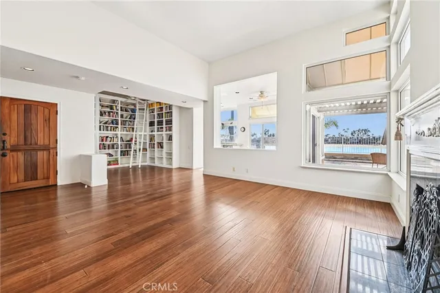 an empty room with wooden floor and fireplace